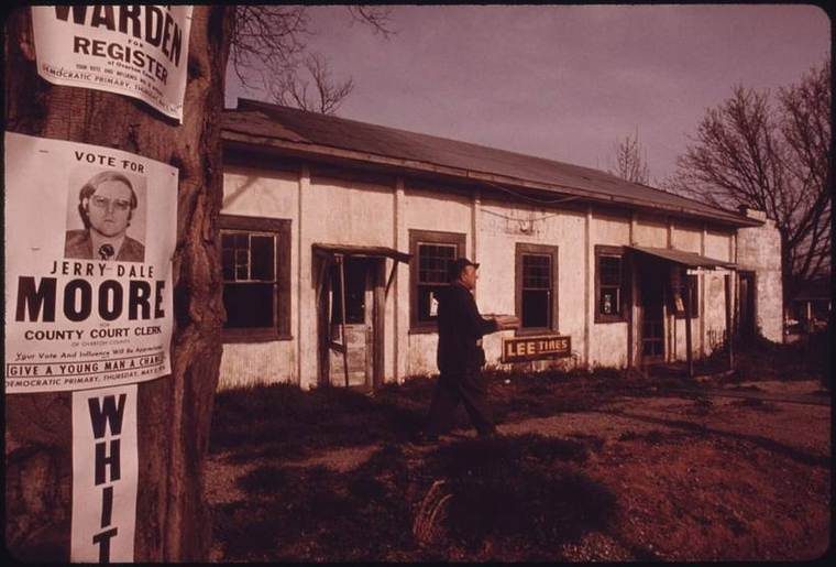 The exterior of a deserted general store building in Crawford, Tennessee, with a retired miner standing outside who had just come from the small post office there.