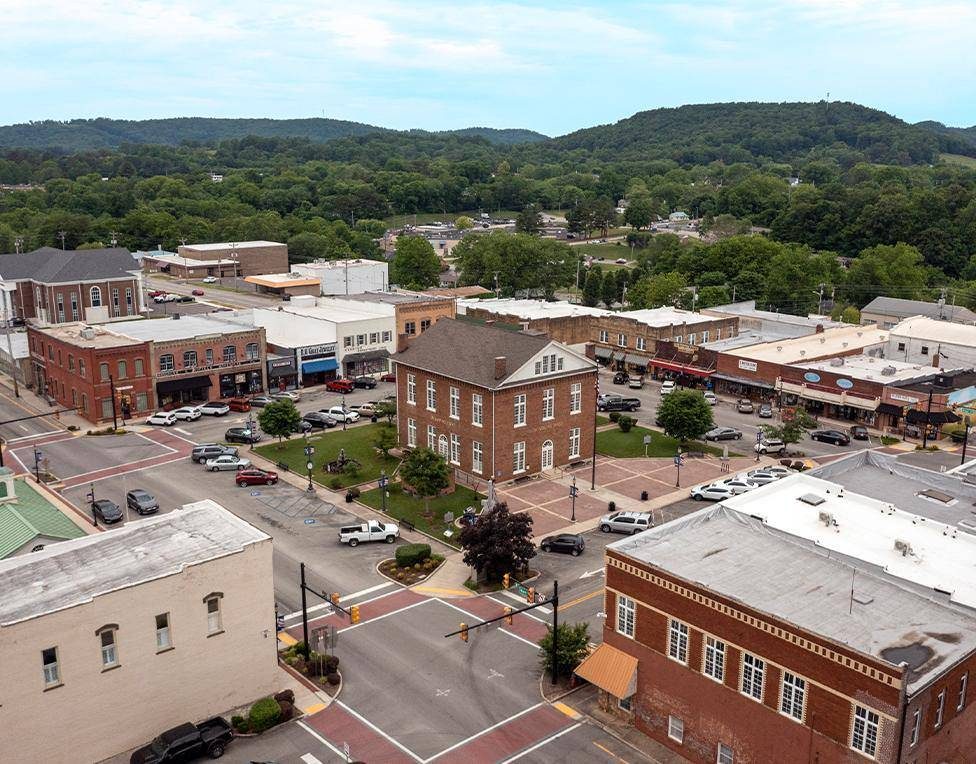 An aerial of downtown Livingston with the courthouse and its lawn in the middle of the square, storefronts on all four sides and the plateau hills behind