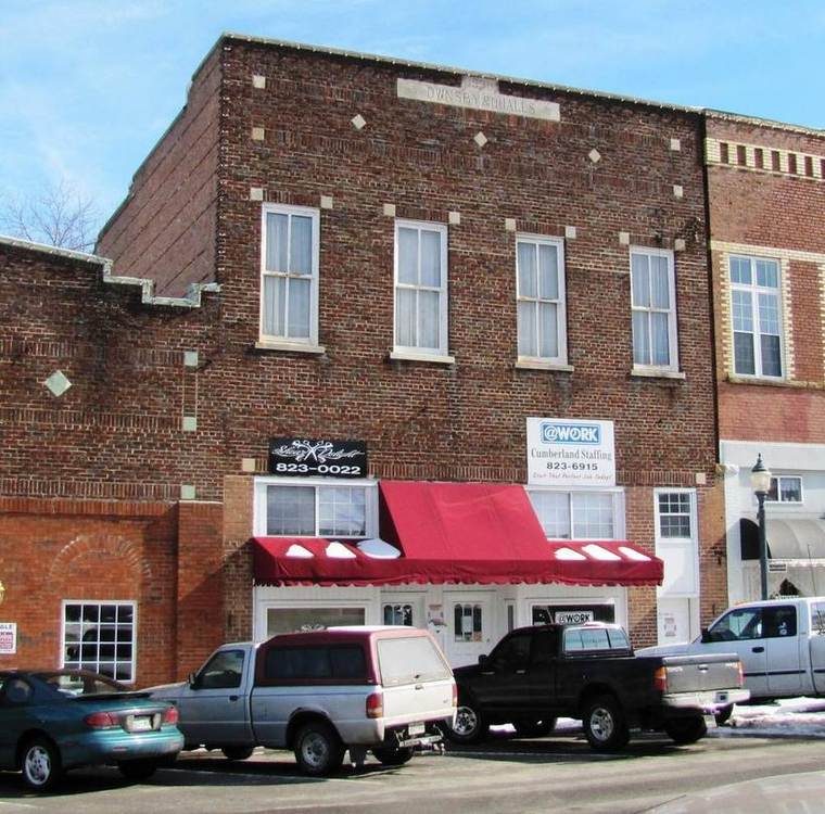 A multi-story brick commercial building from 1930, now used as offices, standing across from the Overton County Courthouse.