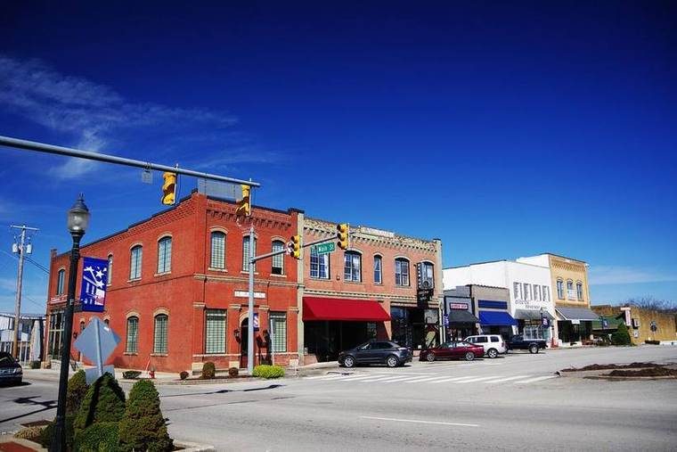 A row of two- and three-story brick commercial storefronts along the western edge of the Livingston courthouse square.