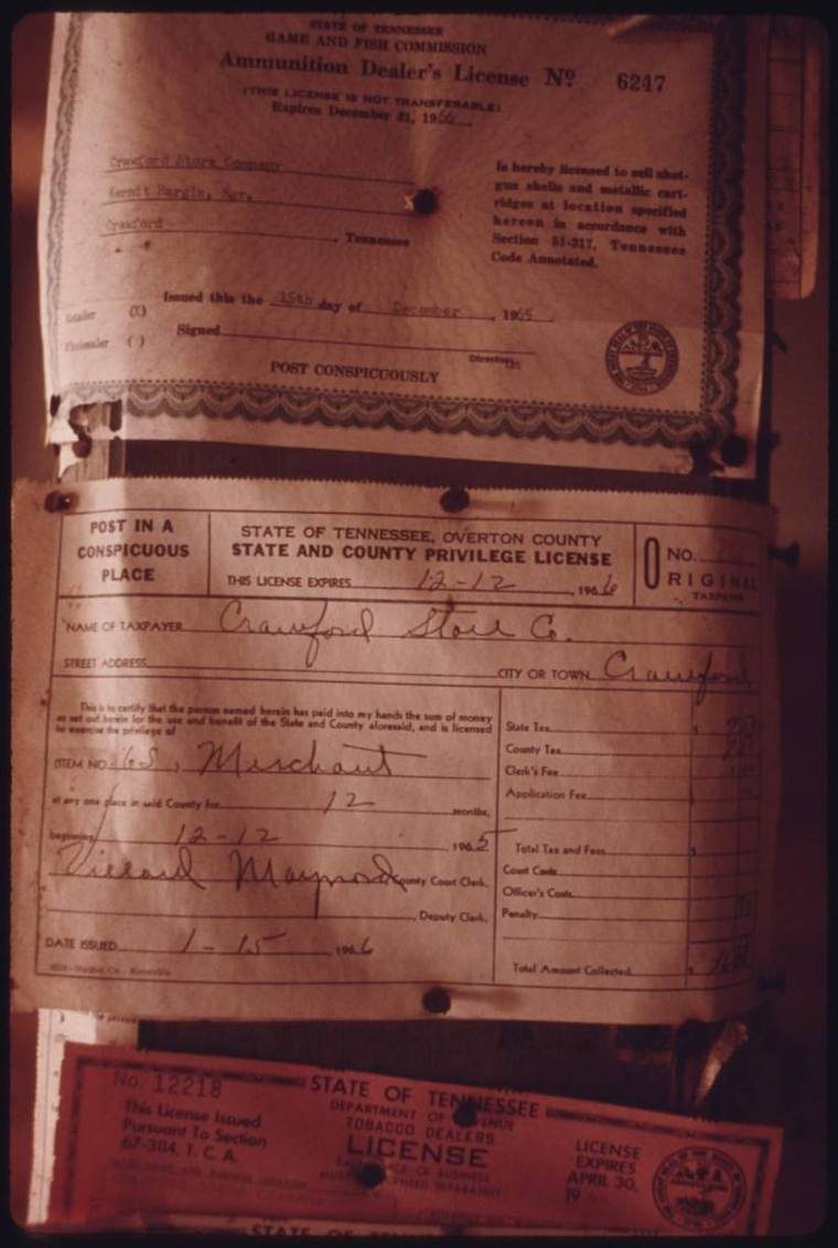 A close-up of various expired state licenses posted inside a deserted general store in Crawford, Tennessee; the last license issued to the store was in 1966.