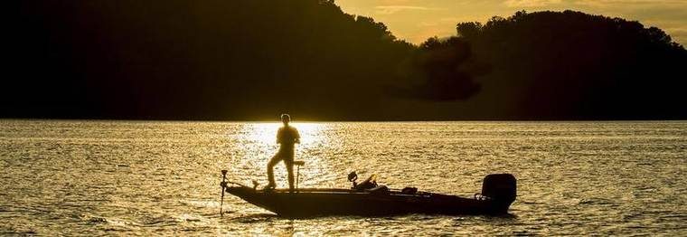 person fishing on a lake during sunset