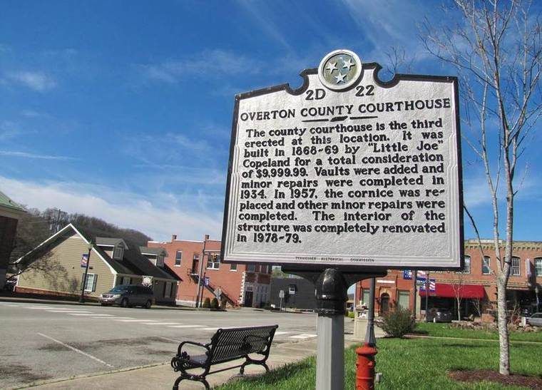 A gray Tennessee Historical Commission cast-metal marker on a post, with text recounting the construction of the Overton County Courthouse.